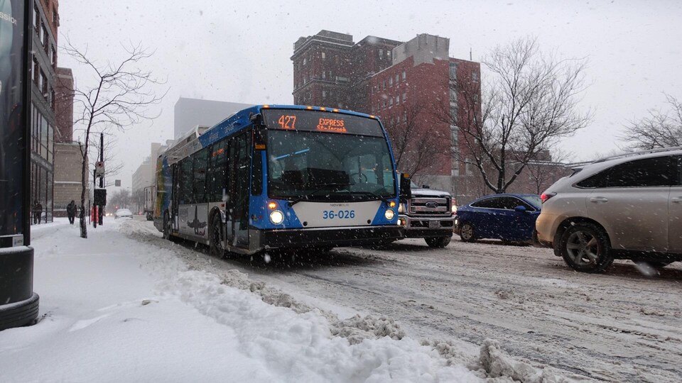 Un autobus de la ville de Montréal sur la route, en hiver.